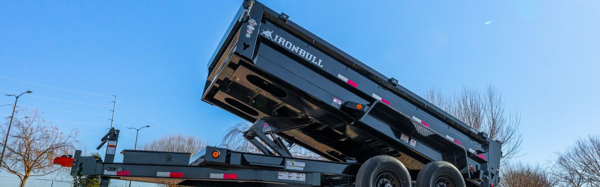 Iron Bull dump trailer with bed raised for sale in Texas at Trailer Place